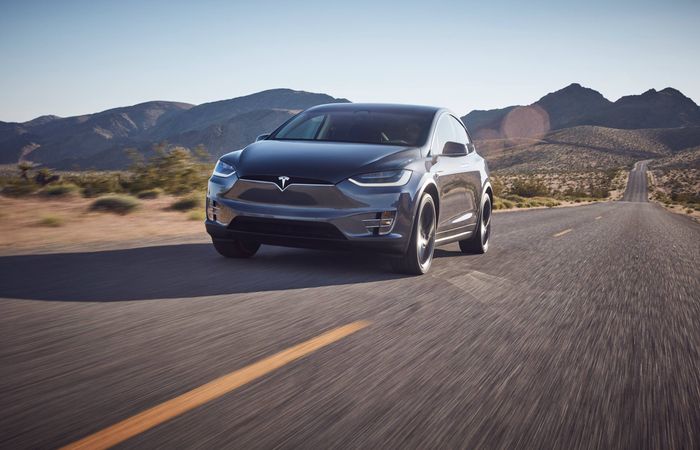 Grey Tesla Model X front driving in desert 
